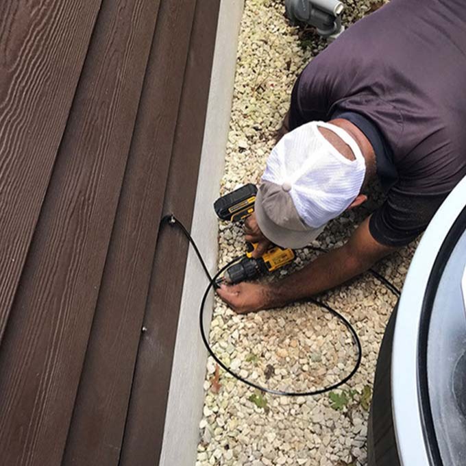 Man maintaining a misting system.
